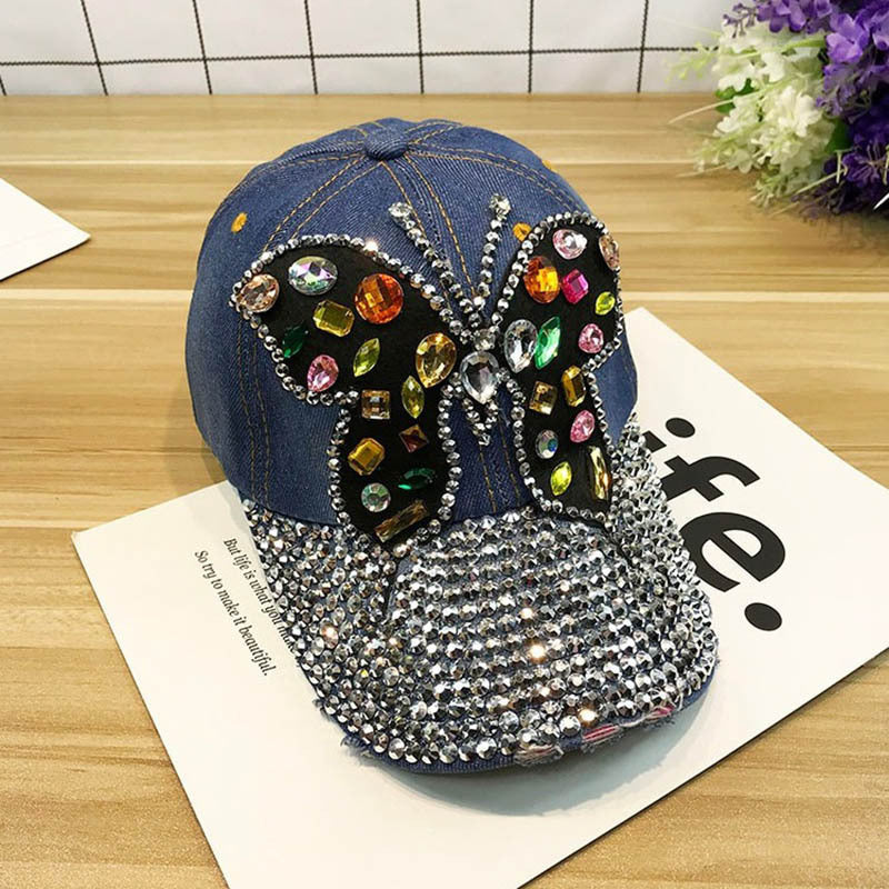 Gorra de béisbol con piedras decorativas y dibujo de mariposa