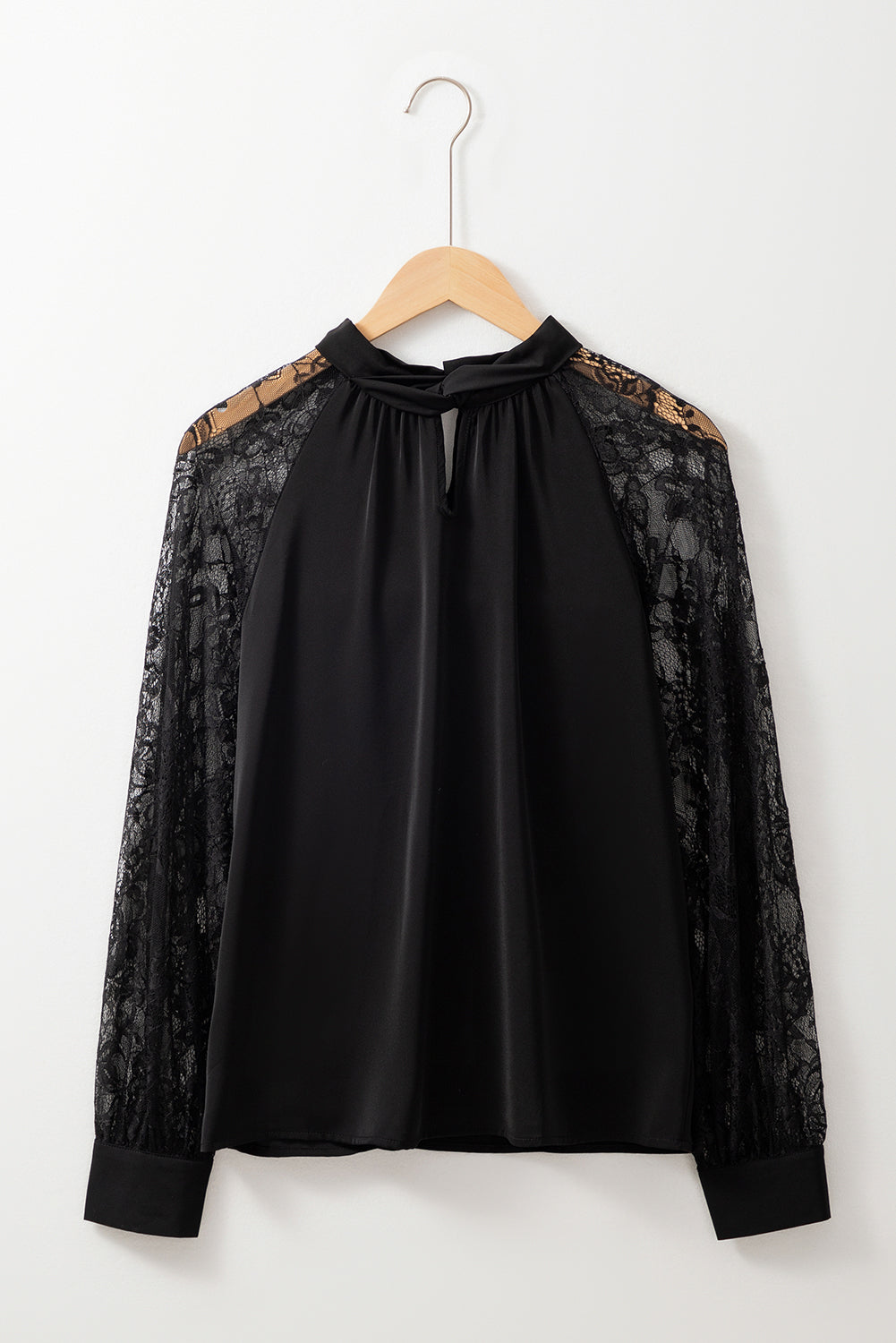 Blusa negra con escote tipo ojo de cerradura y encaje floral, mangas raglán