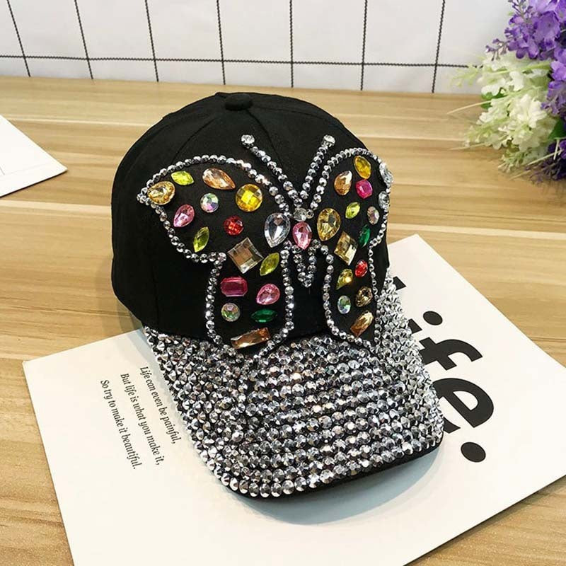 Gorra de béisbol con piedras decorativas y dibujo de mariposa
