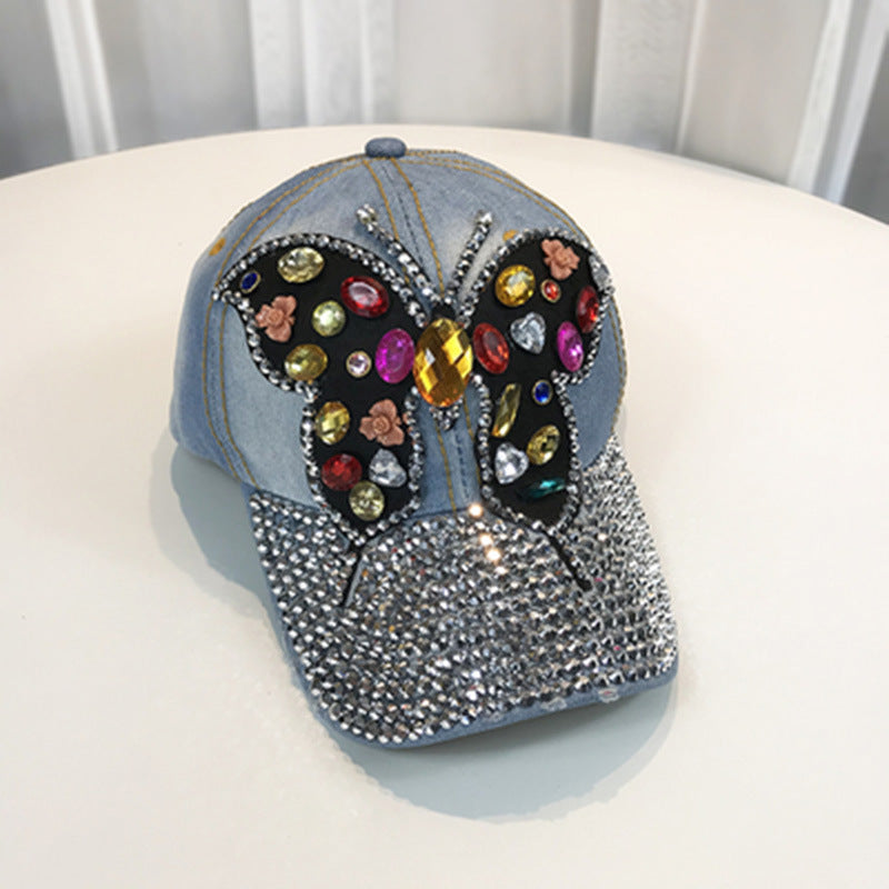 Gorra de béisbol con piedras decorativas y dibujo de mariposa