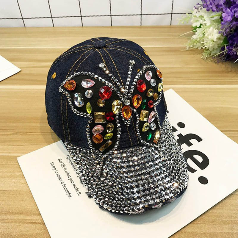 Gorra de béisbol con piedras decorativas y dibujo de mariposa