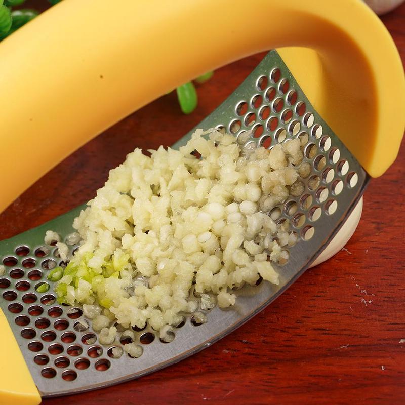 Curved stainless steel garlic crusher