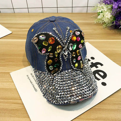 Gorra de béisbol con piedras decorativas y dibujo de mariposa