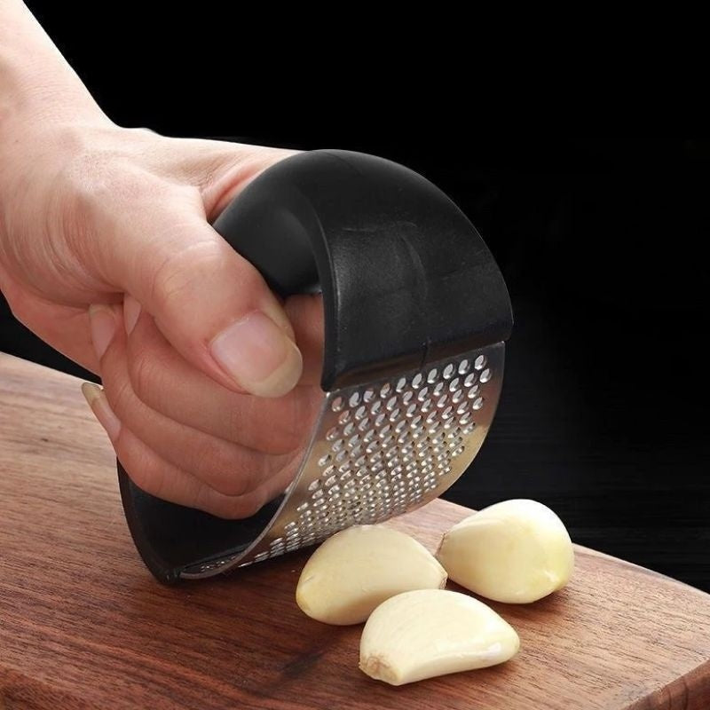 Curved stainless steel garlic crusher